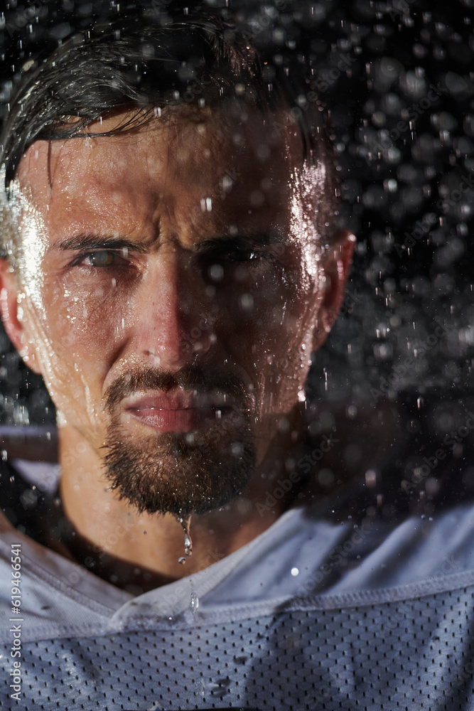 American Football Field: Lonely Athlete Warrior Standing on a Field Holds his Helmet and Ready to Play. Player Preparing to Run, Attack and Score Touchdown. Rainy Night with Dramatic Fog, Blue Light