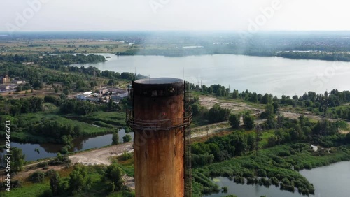 Old industrial plant chimney with coming smoke. Enviroment pollution concept. Close up drone view. photo