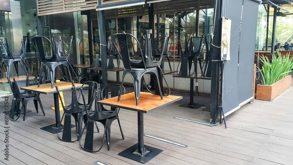 Empty table chairs in front of a restaurant. Empty wooden chairs and tables in front of the cafe. selective focus. Empty table chairs in front of a restaurant. Empty wooden chairs and tables in front of the cafe. selective focus.
