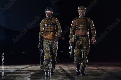 Two professional soldiers marching through the dark of night on a dangerous mission, epitomizing their unwavering bravery, unwavering teamwork, and the high-stakes intensity of their specialized
