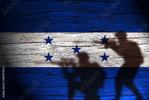 Honduras flag on wood and soldier shadow