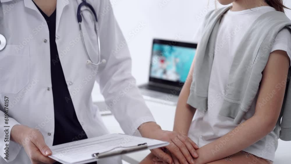 Doctor reassuring kid patient while both are sitting and discussing something opposite each other. Empathy in medicine concept Doctor reassuring kid patient while both are sitting and discussing something opposite each other. Empathy in medicine concept