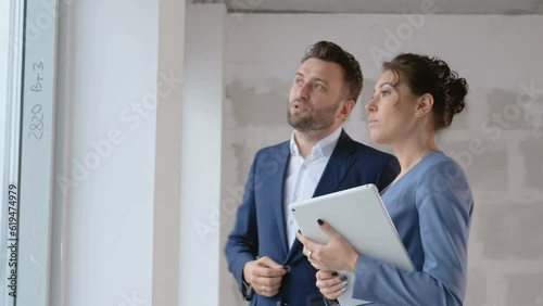 Two business persons talking about investment in real estate indoors. Construction concept: female agent speak with consultant close up