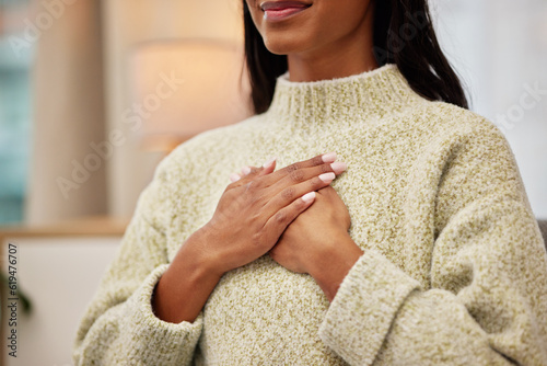 Closeup of a woman holding her chest while breathing for calm, peace and zen mindset for meditation. Breathe, relax and zoom of a female person hands on her heart for grateful gesture in living room.