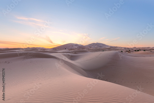 Sunset over the sand dunes in the desert. Arid landscape of the Sahara desert