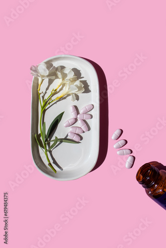 Bilde på lerret pink pills, flowers and pill box on a pink background