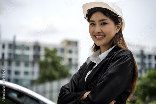 Portrait smiling young Asian engineer woman with building background, happy Engineer woman concept