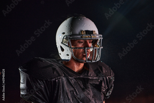 American Football Field: Lonely Athlete Warrior Standing on a Field Holds his Helmet and Ready to Play. Player Preparing to Run, Attack and Score Touchdown.