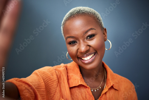 Fototapeta Naklejka Na Ścianę i Meble -  Beauty, selfie and black woman with a smile, profile picture and freedom with against a grey studio background. Portrait, female person or model with happiness, confident or fashion with social media