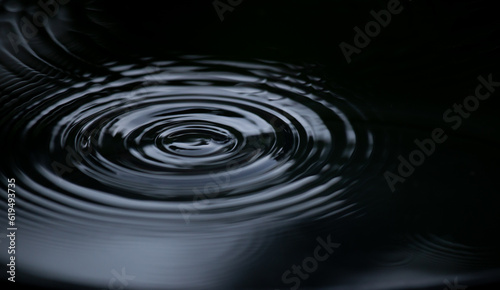 Ripple of water or water drop splash on black background. Abstract shape out of the water