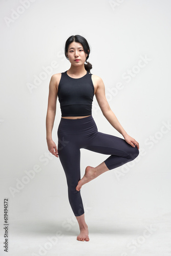 beautiful Asian woman practicing yoga indoors 