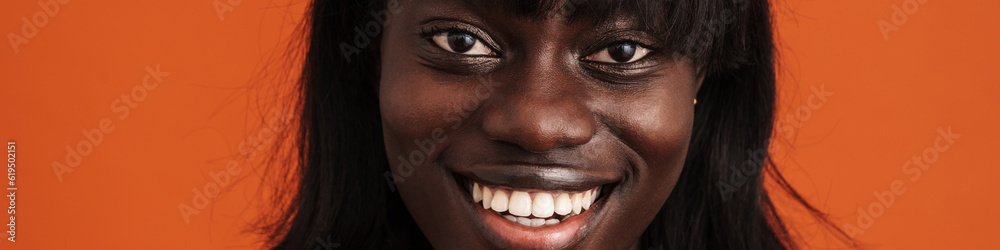 Close up portrait of smiling african lady over orange background