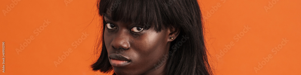 Obraz premium Serious african lady demonstrates refusal sign isolated over orange background
