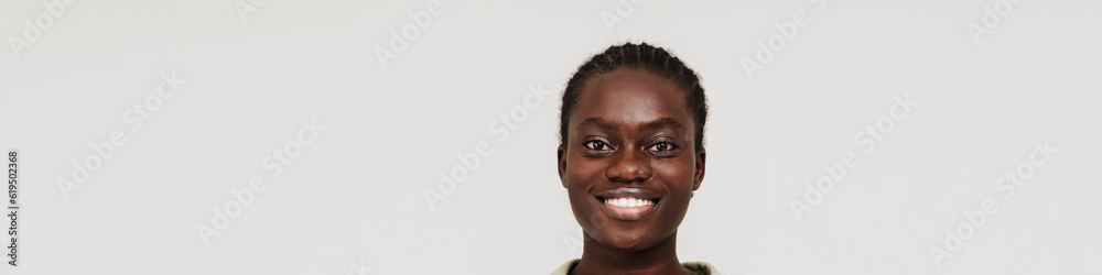 Young black woman with afro braids smiling at camera
