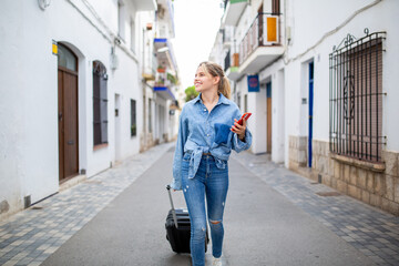 Young travel woman walking with mobile phone and bag