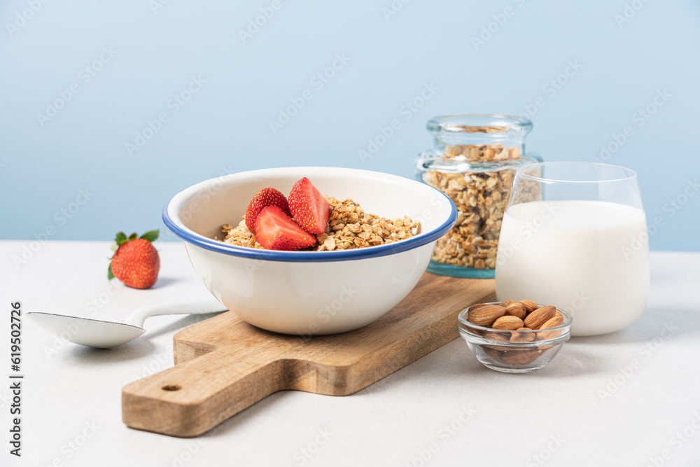 Granola in bowl with strawberries on blue background with copy space. Food breakfast background Granola in bowl with strawberries on blue background with copy space. Food breakfast background