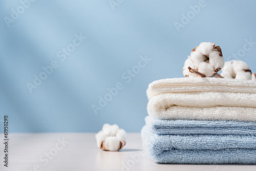 Foto Stack of organic cotton terry towels on blue background with copy space