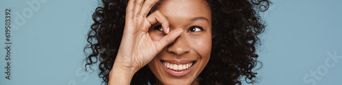 Shirtless black woman showing ok sign and laughing