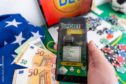 Smartphone with gambling mobile application, ball and money banknotes. Sport and betting concept