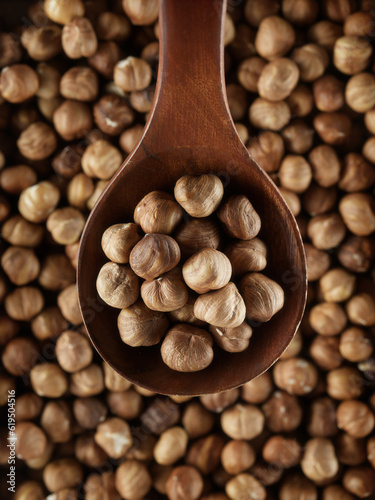 Peeled hazelnuts in close-up with wooden spoon. View from above. Promotional photo of healthy nut for online store and marketplaces.