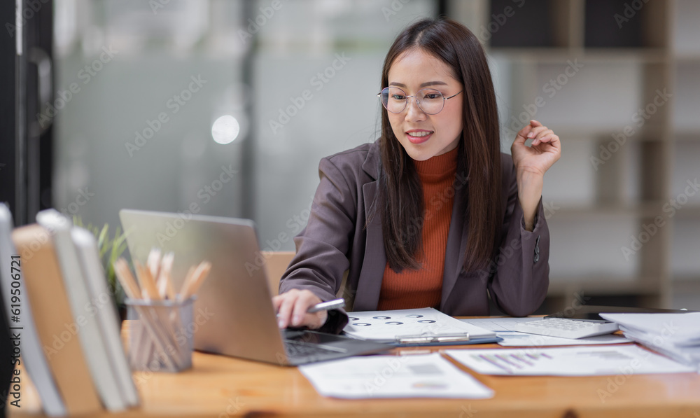  Asian business woman wear glasses or accountant working on calculator to calculate business data, accounting document and laptop computer at office, business concept