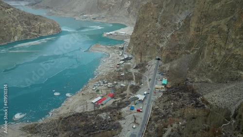 Karakoram Highway and hotels near frozen Attabad lake from Baskochi Meadows in winter season Hunza Valley Gilgit Baltistan. Attabad tunnels are part of Pakistan China trade route on this highway