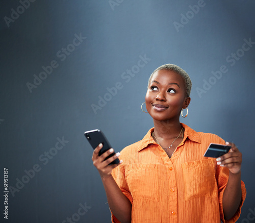 Thinking, ecommerce and credit card with a black woman using her phone in studio on a gray background. Mobile, online shopping and finance payment with a female shopper searching for a deal or sale