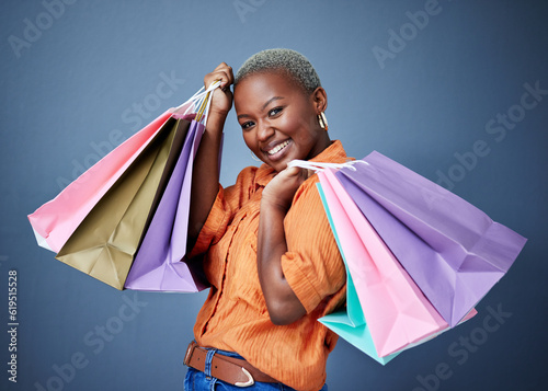 Fototapeta Happy, portrait and woman with shopping bags in studio after sale, promotion or discount