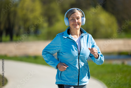 Smiling woman in blue blazer running in the park