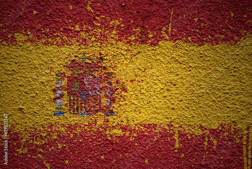 painted big national flag of spain on a massive old cracked wall