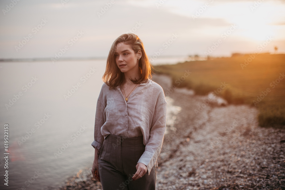 Young woman walking near lake, enjoying summer time. Young woman walking near lake, enjoying summer time.