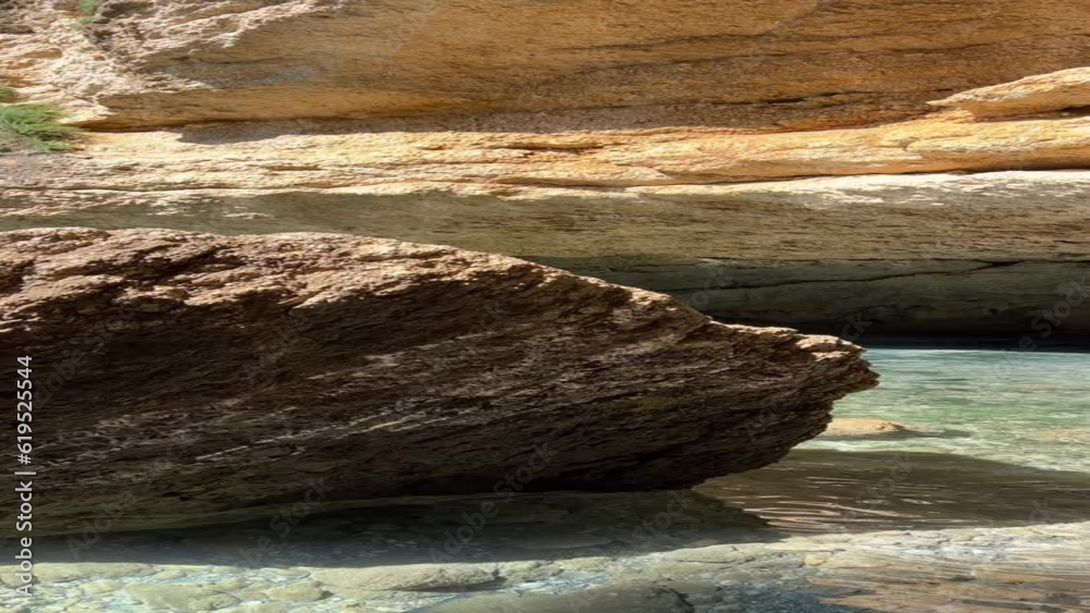 Rocks and sea pebble beach, vertical video.