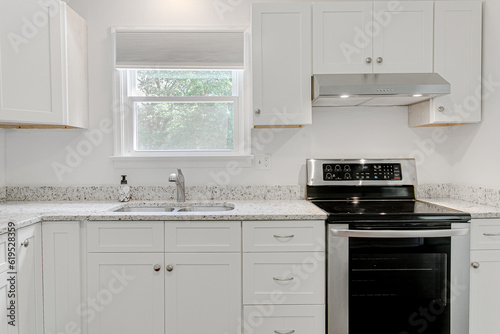 Amazing bright white modern farmhouse traditional kitchen interior with backyard nature views and granite marble countertops