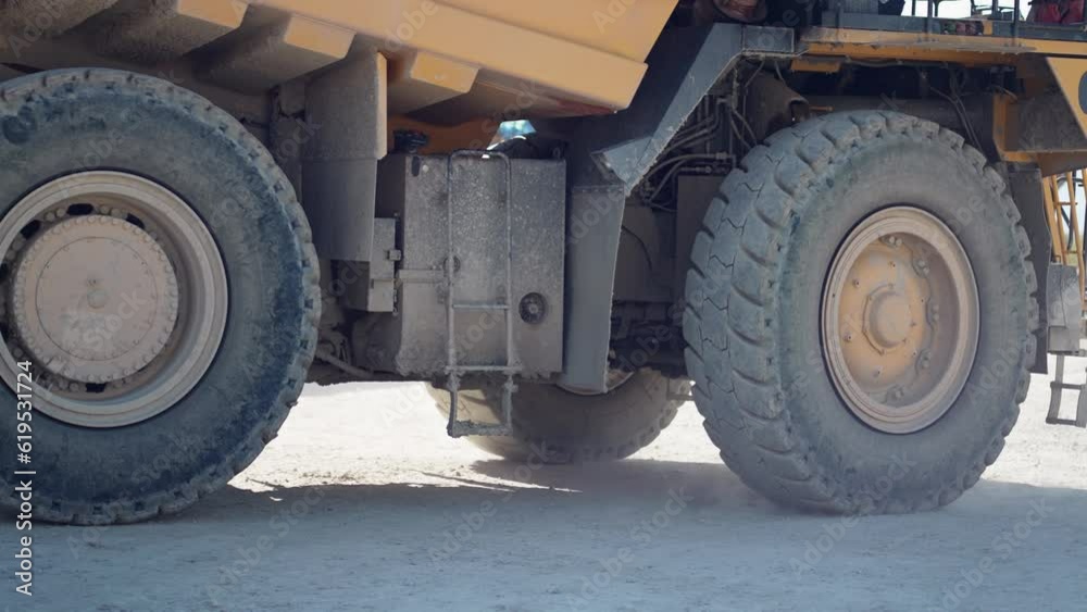 Heavy mining truck on the iron ore opencast mining quarry, industrial exterior, ore mining quarry on sunny day, summer, slow motion