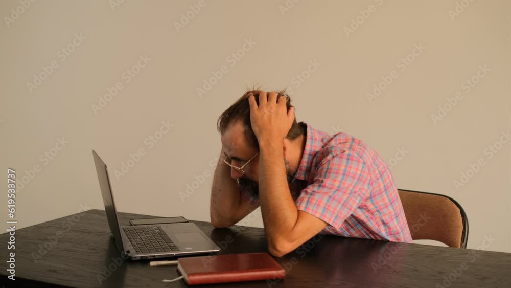 Man anxiously working on a laptop Man anxiously working on a laptop