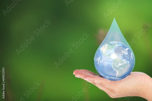 Water drop in human hand on natural background