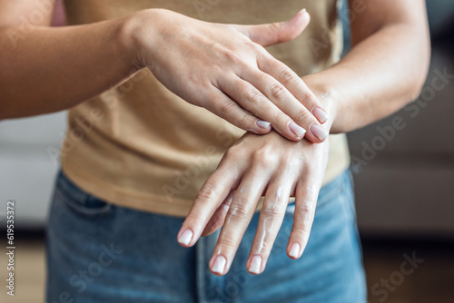 Woman putting essential oils on her hands at home