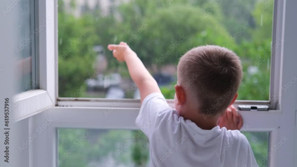 The boy opened the window and held out her hand. The rain drips not the child's hands. The boy opened the window and held out her hand. The rain drips not the child's hands.