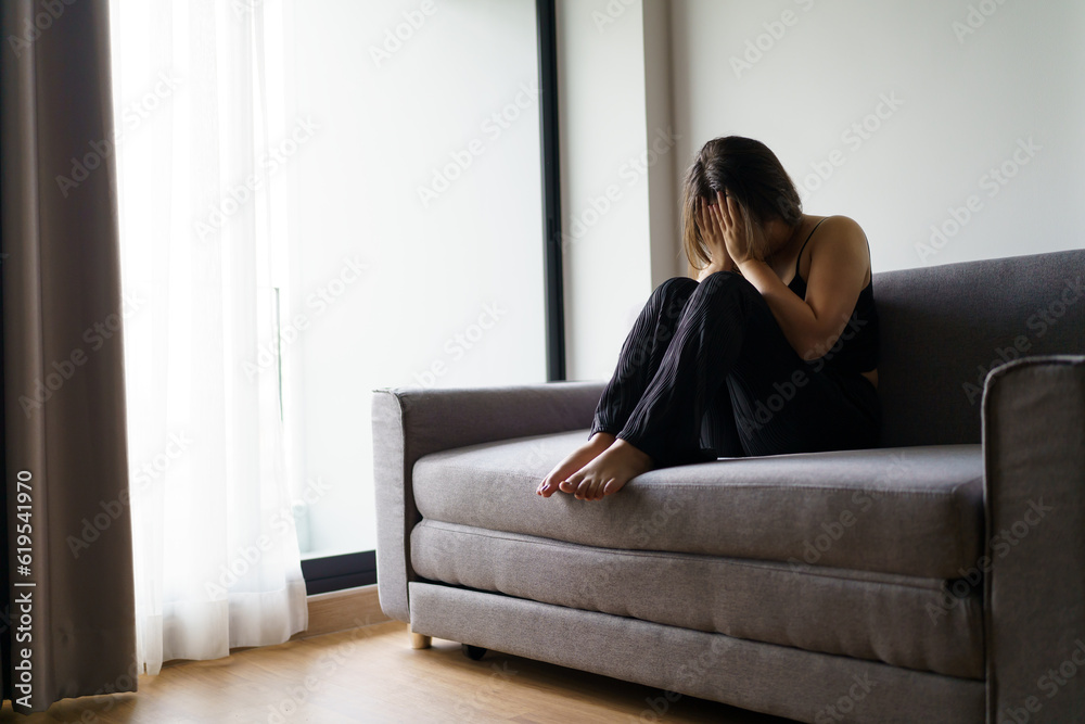 Sad woman thinking about problems sitting on a sofa upset girl feeling lonely and sad from bad relationship or Depressed woman disorder mental health.