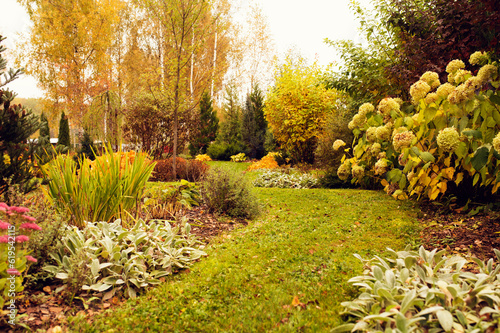 beautiful autumn garden view with curvy lawn pathway. Private natural country garden in october