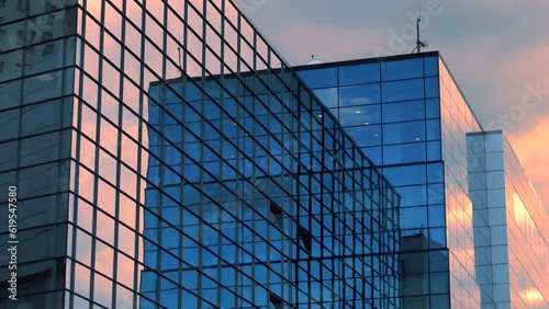 Office builiding, exterior view on the sky background with colorful yellow and orange clouds, public urban scene, panning, mid shot, time lapse, long exposure, multiple exposure, perspective. ProResHQ