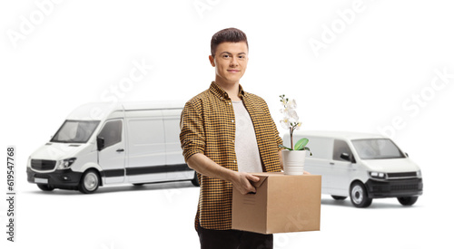 Guy standing in front of vans with a cardboard box and an orchid flower pot © Ljupco Smokovski