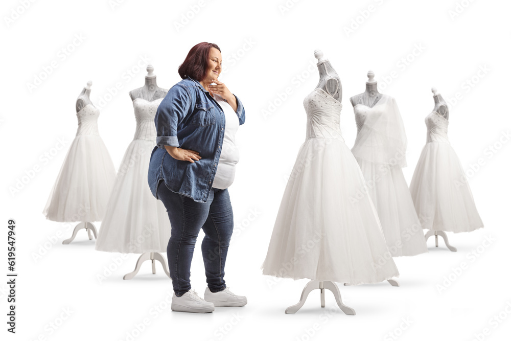 Overweight woman looking at bridal gowns and thinking