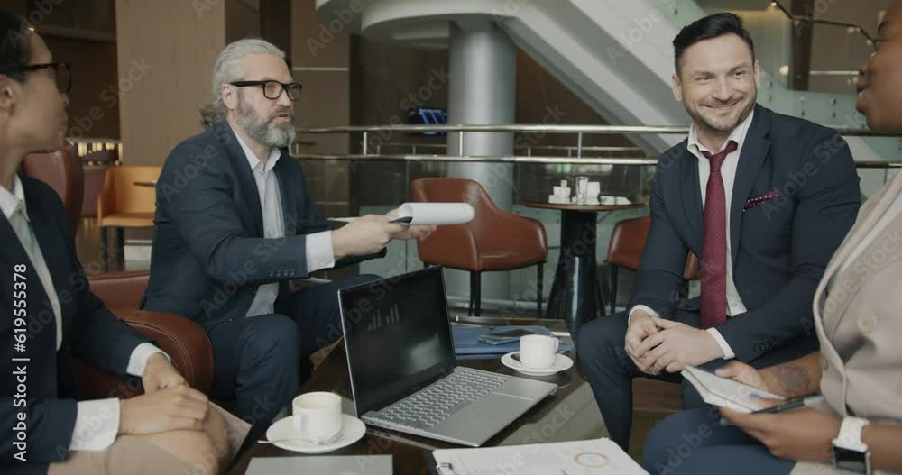 Business men and women are talking in hotel lobby then shaking hands enjoying successful deal. Communication and corporate lifestyle concept. Business men and women are talking in hotel lobby then shaking hands enjoying successful deal. Communication and corporate lifestyle concept.