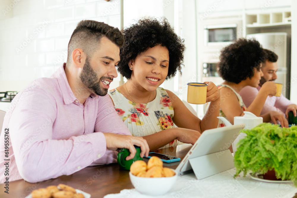 happy couple looking at tablet and touching screen at home happy couple looking at tablet and touching screen at home