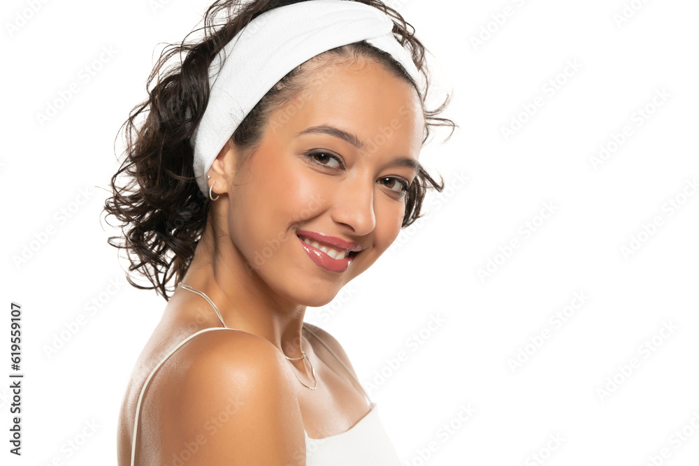 Young dark skinned smiling woman with makeup and headband posing on a white background Young dark skinned smiling woman with makeup and headband posing on a white background