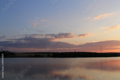 A body of water with a sunset in the background