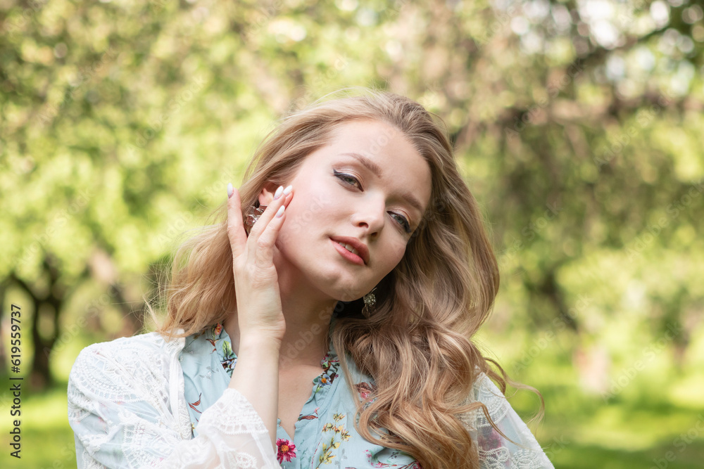 portrait of young girl with long blond hair walks in the park 