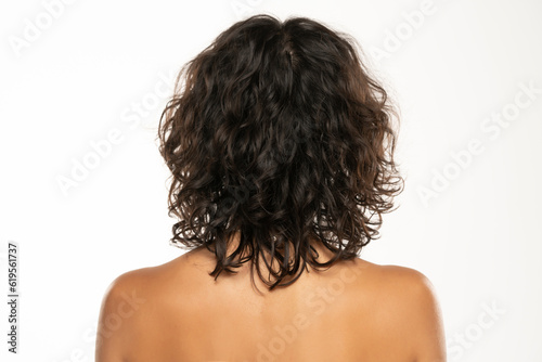 Back view head shot of beautiful curly dark wavy hair woman against white background