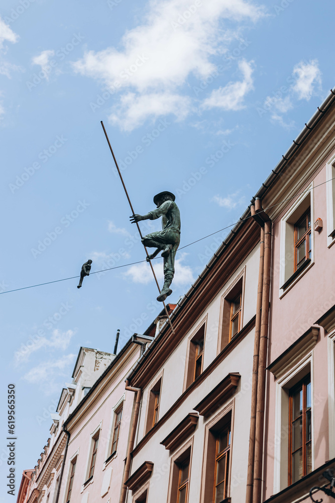 Lublin, Poland- May 10, 2023:  Sculpture of Rope Walkers at highline at Market Square. Equilibrist or balance master in old town. The view of the statue in the city center on the old street - obrazy, fototapety, plakaty 
